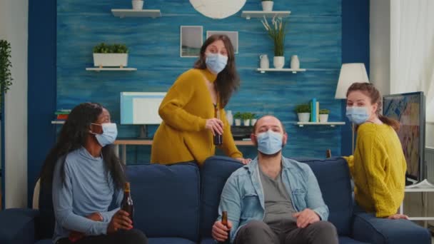 Amis avec masque de protection passer du temps dans le salon avec réunion en ligne — Video