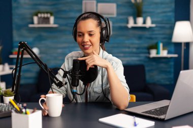 İçerik yaratıcısı kulaklık takıyor ve seyircileri için yeni bir podcast serisi yapıyor..