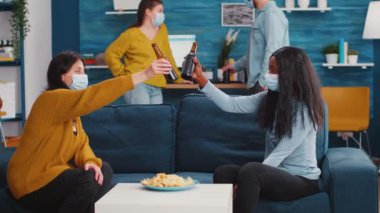 Koruyucu maskeli, bira içen mutlu çok ırklı arkadaşlar.