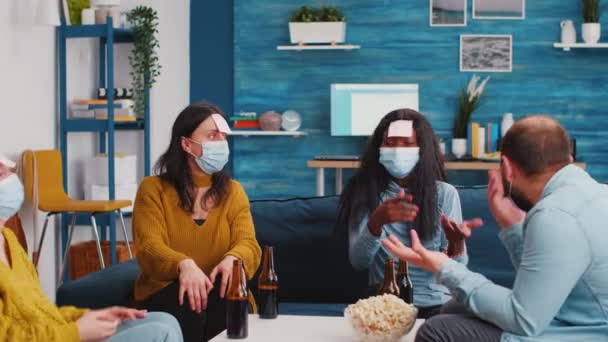 Colegas multirraciales con máscaras protectoras jugando con notas adhesivas — Vídeo de stock