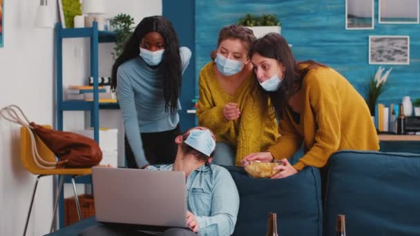 Gemengde race vrienden met gezichtsmaskers op zoek in laptop op grappige clip — Stockvideo