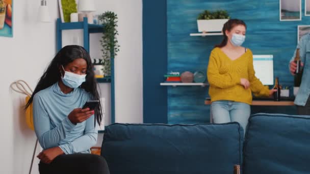 Diversos amigos pendurados na sala assistindo clipe no smartphone — Vídeo de Stock