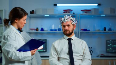 Araştırmacı nörolog adama belirtileri soruyor. Not alıyor.