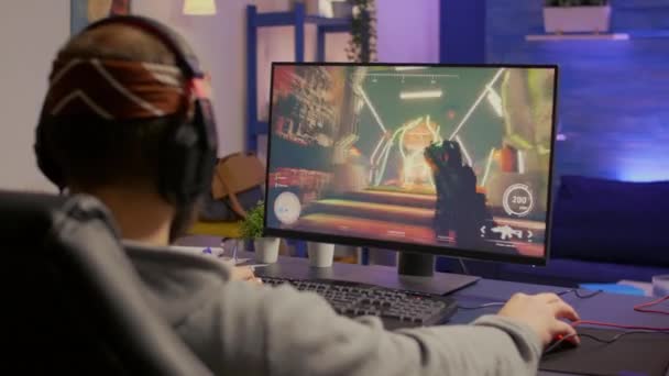 Jugador profesional con auriculares que realiza videojuego shooter en primera persona — Vídeo de stock