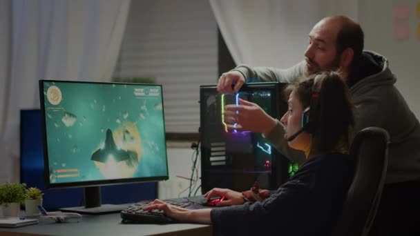 Man gamer teaching his girlfriend playing space shooter video game on RGB  powerful personal computer. Pro cyber woman with headset performing video  games streaming from home during online tournament Stock Photo 