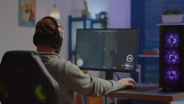 Terug schot van gelukkig man gamer winnen eerste persoon shooter video game — Stockvideo