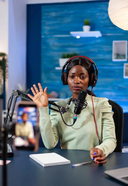 Afrikalı blogcu kameraya bakıyor ve el sallıyor