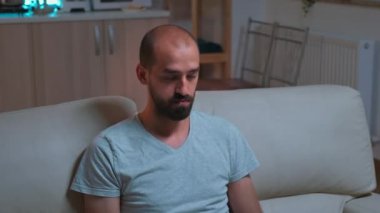 Yorgun adam televizyonun karşısında oturmuş yaşam tarzı bilgisi yazıyor.