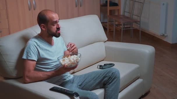 Hombre concentrado viendo películas de entretenimiento mientras hace expresión facial — Vídeos de Stock