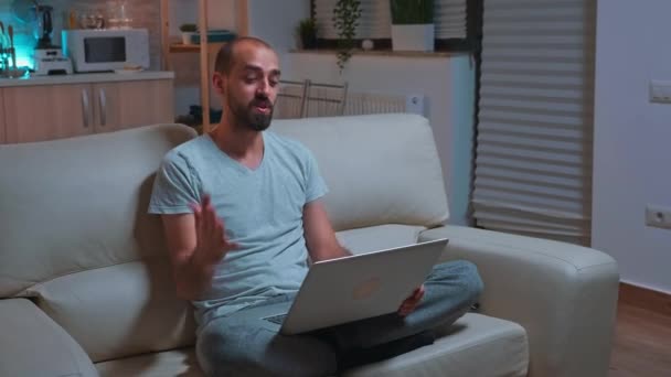 Homme concentré travaillant sur ordinateur portable pendant le vidéocall d'affaires — Video