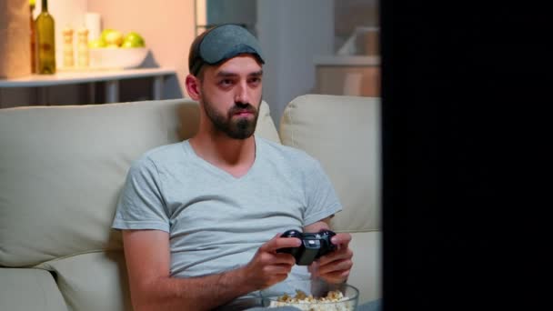 Primo piano dell'uomo con maschera di sonno degli occhi che gioca ai videogiochi con joystick — Video Stock