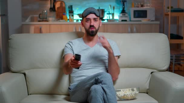 Homem adulto comendo pipocas em pé na frente da televisão — Vídeo de Stock