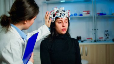 Ekokardiyografi kulaklığı olan hasta muayene sırasında tıp araştırmacısıyla konuşuyor.