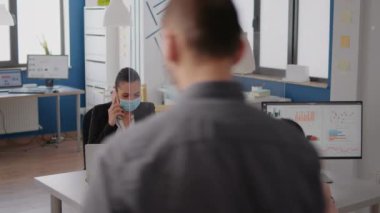 Koruma maskeli serbest çalışan yeni strateji için telefonda konuşuyor.
