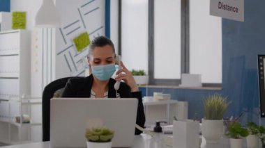 Koruyucu yüz maskeli girişimci sabit hattan konuşuyor