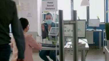 Meslektaşına istatistik gösteren yüz maskeli bir yönetici.