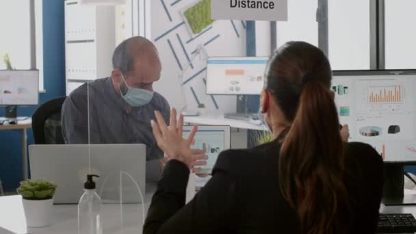 Rekan kerja dengan masker wajah pelindung berbicara tentang statistik manajemen — Stok Video