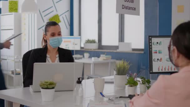 Tıbbi maskeli iş adamları şirket ofisinde birlikte çalışıyorlar. — Stok video