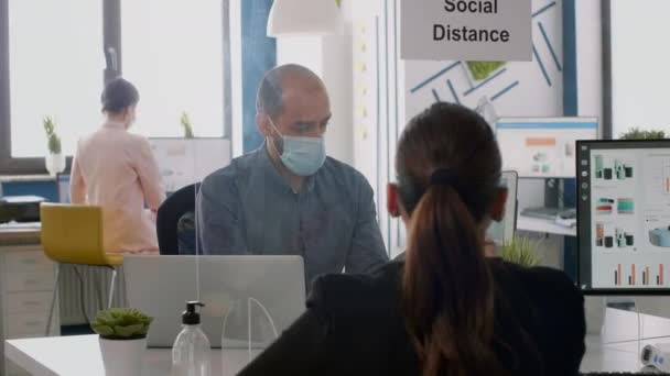 Two collegues with face masks working at marketing project while sitting in company office — Stock Video