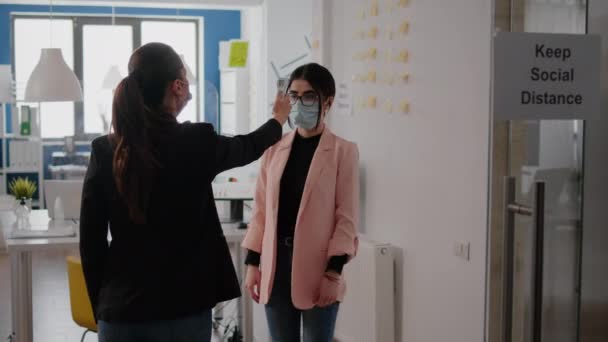 Affärskvinna bär ansiktsmask kontrollera arbetstagare temperatur — Stockvideo
