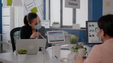 Finansal projede birlikte çalışan yüz maskeli iş arkadaşlarını kapatın.