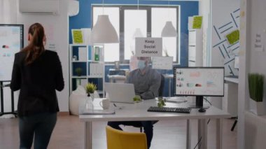 Koruyucu yüz maskesi takan serbest çalışan ekip sıcaklığını tıbbi termometre kullanarak kontrol ediyor.