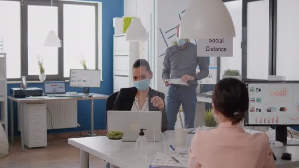 Команда з масками медичного обличчя працює на маркетинговому проекті. — стокове відео