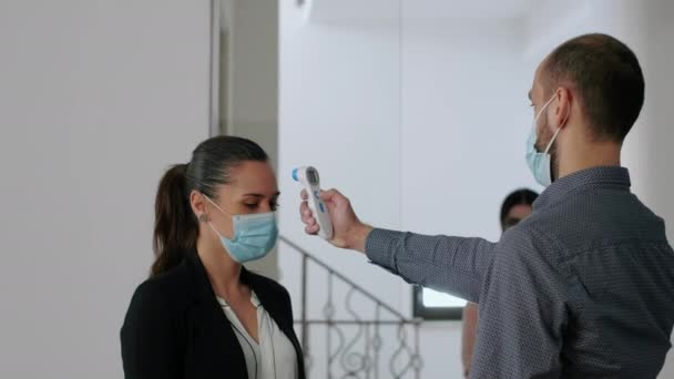 Freelancer z maską ochronną zmierzyć temperaturę z termometrem — Wideo stockowe