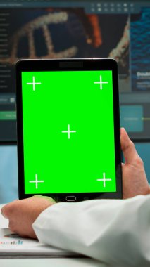 Laboratuvarda yeşil ekran tablet kullanarak oturan biyokimyacıyı kapat.