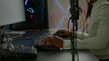 Afrikalı oyuncu oyun odasında oturan ses karıştırıcıyı kontrol ediyor