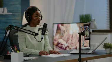 Gülümseyen sosyal medya yıldızı kameranın önünde el sallıyor.