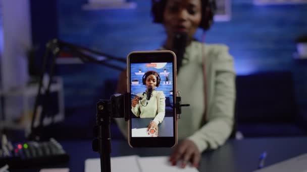 Крупный план смартфона запись черной женщины влиятельной смотреть в камеру — стоковое видео