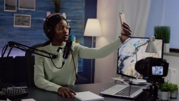 Чорна жінка відеоблогер приймає селфі за допомогою смартфона під час потокового передавання — стокове відео