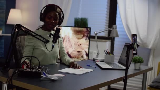 Afrikansk influencer bär hörlurar kontrollerar ljud inspelning nya podcast — Stockvideo