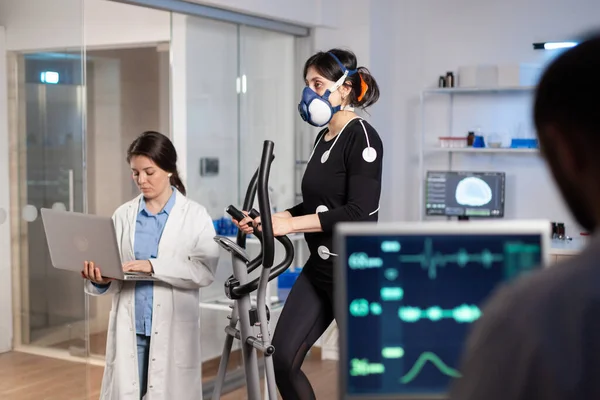 Team of medial researchers monitoring vo2 of woman performance