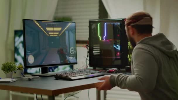 Cyber sport gamer het dragen van een koptelefoon spelen eerste persoon shooter videogame — Stockvideo