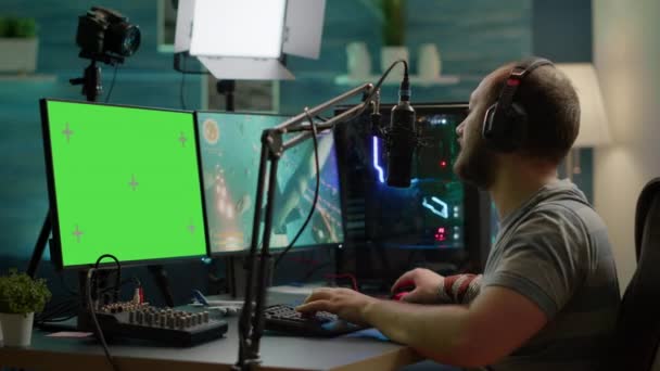 Киберпреступники играют в онлайн-видеоигры на зеленом экране мощного компьютера — стоковое видео