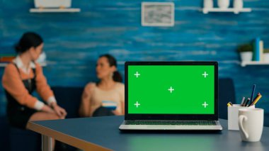 Arka planda kanepede oturan iki kadın.