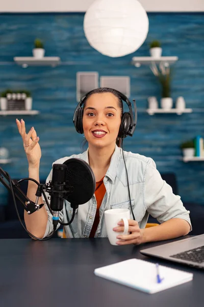 Content creator looking at camera while talking into microphone during beauty podcast.
