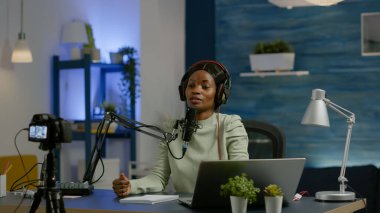 Afrikalı sosyal medya kadını mikrofona konuşan dizüstü bilgisayara bakıyor