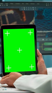 Erkek kimyager elinde yeşil ekran tableti tutuyor.