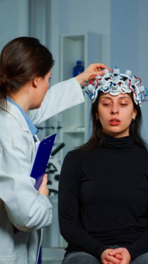 Nöroloji doktoru, tedaviyi açıklayan kulaklığı kontrol ediyor.