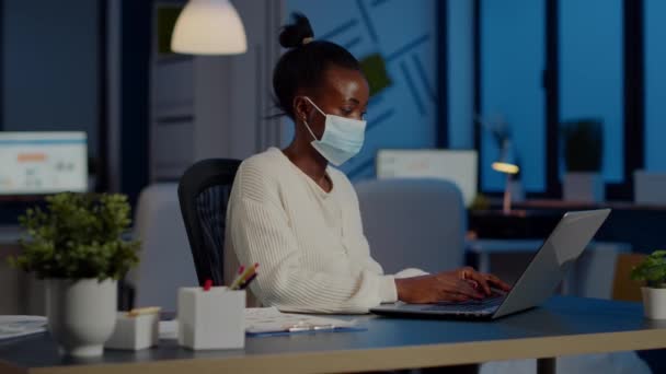 Suratı koruma maskeli Afrikalı bir çalışan fazla mesai yapıyor.