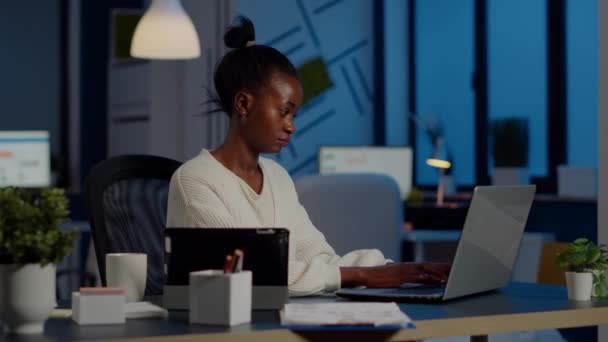 Multitasking nero donna d'affari che lavora al computer portatile e tablet nello stesso tempo — Video Stock