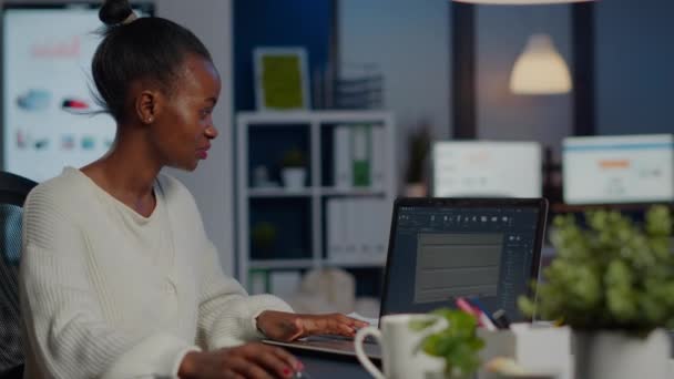 ラップトップ分析プロジェクトを見る黒人女性エンジニアデザイナー — ストック動画