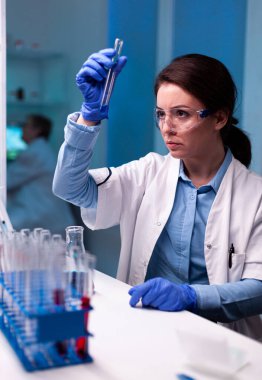 Kimyager sıvı örneğini analiz ediyor ve genetik enfeksiyonu keşfediyor.