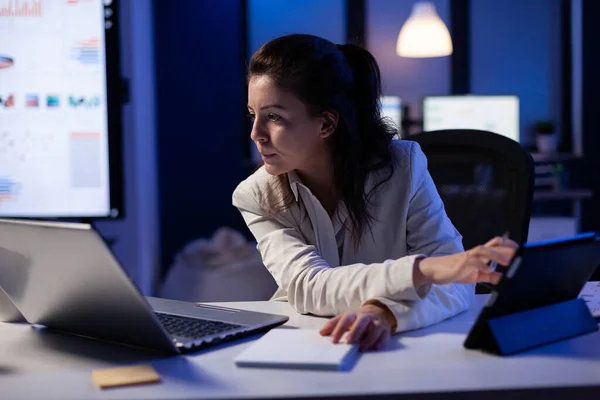 Manager donna utilizzando computer portatile e tablet nello stesso tempo lavorando su rapporti finanziari — Foto Stock