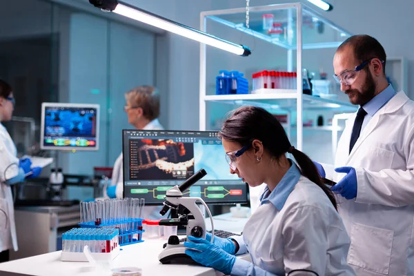 Mujer científica analizando virus con microscopio en laboratorio de química de investigación —  Fotos de Stock