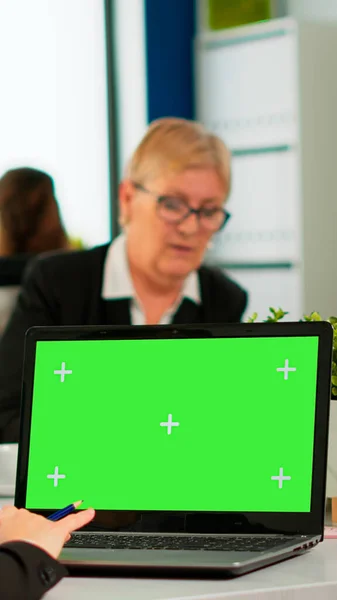 Over de sholder van manager zittend aan vergadertafel kijkend naar laptop met groen scherm — Stockfoto