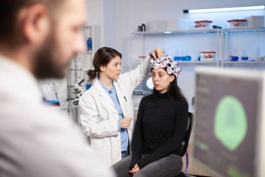 Tıp laboratuarındaki nörolog doktor kulaklığı ayarlıyor.